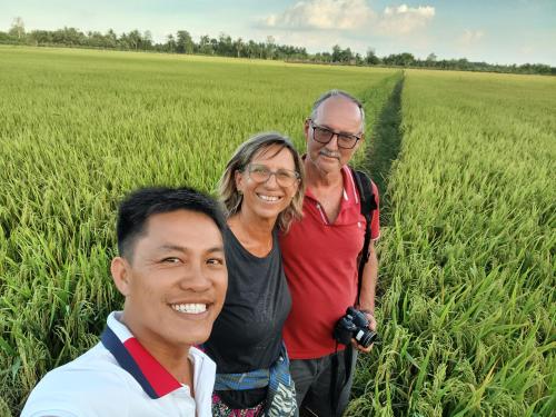 a group of three people standing in a field at Experience Homestay in Can Tho