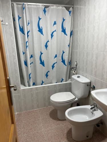 a bathroom with a toilet and a shower curtain with dolphins at Apartamento CA VALEN 4 in Peniscola