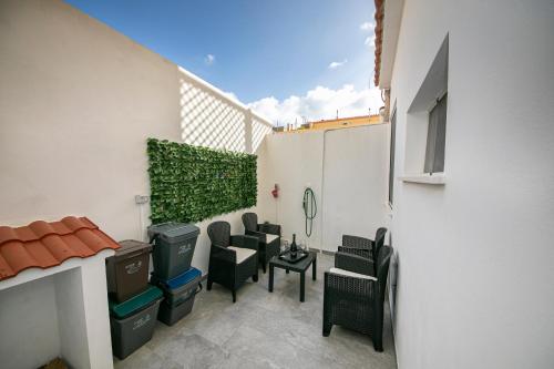 a patio with black chairs and a table at Casa LoiS in Gonnesa