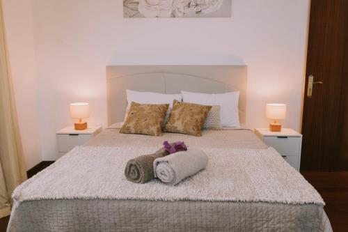 a bedroom with a bed with two towels and two lamps at Bela Vista House in Ponta Delgada