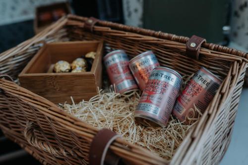 a wicker basket with two cans and a box at Rose & Star Cottage in Frome