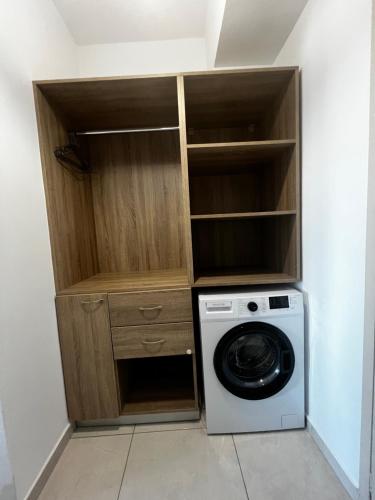 a laundry room with a washing machine in a closet at Blue Sand Apartment in Analipsi