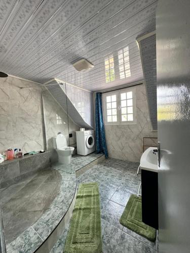 a large bathroom with a sink and a toilet at Kaz Ti Sèr in Saint-Denis
