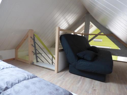 - une chambre mansardée avec une chaise bleue dans l'établissement Maison de pays 500 m de la plage, à Saint-Gilles-Croix-de-Vie