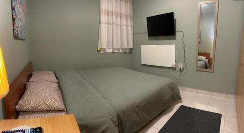 a bedroom with a bed and a table and a television at Anna’s house in Síndos