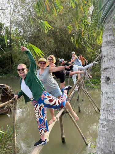 a group of people crossing a bridge over a river at Experience Homestay in Can Tho