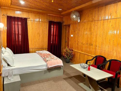 a bedroom with a bed and a table and chairs at Kashmiri kothi - Srinagar stay in Srinagar