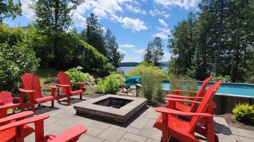 un patio con sedie rosse e braciere di Chalet Hill Top Inn a Messines