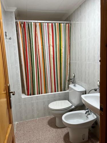 a bathroom with a toilet and a shower curtain at Apartamento CA VALEN 5 in Peñíscola