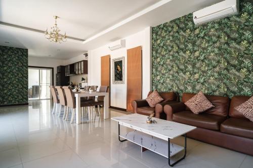 a living room with a couch and a table at Queen Massarossa Pool Villa Pattaya-25 in Pattaya