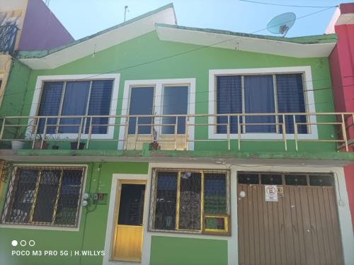 a green house with a balcony on top of it at Villa De Juarez Carmen in Xicotepec de Juárez