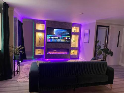 a living room with a couch and purple lighting at The Exclusive Jacuzzi Apartment with Fireplace & Parking in Birmingham