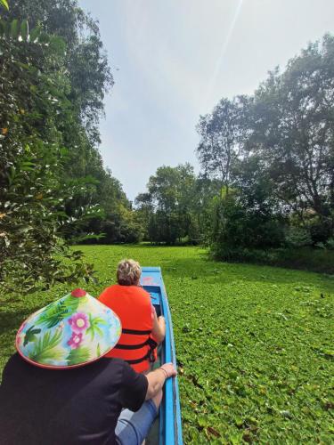 two people riding on a boat in a field at AUTHENTIC HOMESTAY in Can Tho