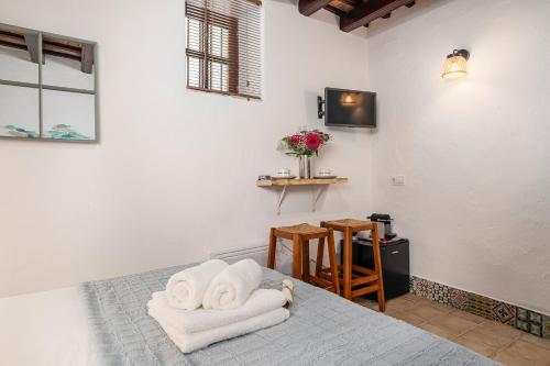 a bedroom with a bed with towels on it at Casa Lunarito in Vejer de la Frontera