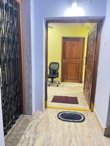 a hallway with a black chair in front of a door at SRI Surya Guest House in Visakhapatnam