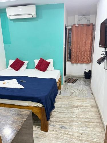 a bedroom with two beds and a blue wall at SRI Surya Guest House in Visakhapatnam
