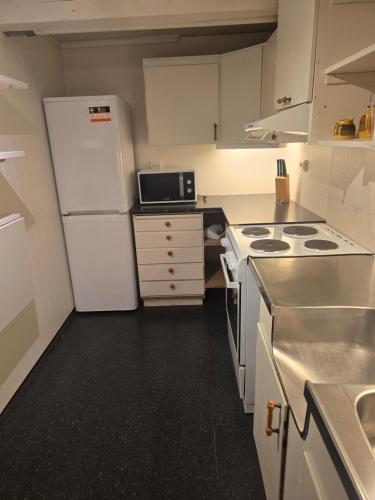 a small kitchen with a white refrigerator and a stove at Hagestova in Volda