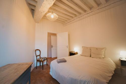 a bedroom with a white bed and a chair at Gîtes Fixey 1 et 2 in Fixin