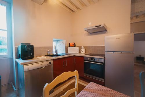 a kitchen with a refrigerator and a counter top at Gîtes Fixey 1 et 2 in Fixin