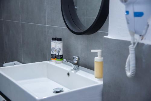 a bathroom sink with a hair dryer and a mirror at mandala central apartment in Rhodes Town
