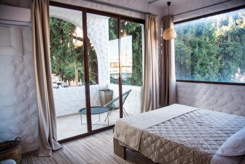 a bedroom with a bed and a large glass window at mandala central apartment in Rhodes Town