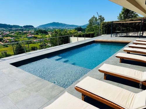 a swimming pool with lounge chairs on a patio at Casa da Aldeia Nova in Venade