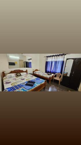 a bedroom with two beds and a couch and a window at Fourseason frankcottage in Chikmagalūr