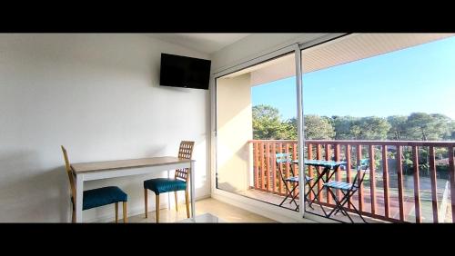 a balcony with a table and chairs and a view of a deck at Studio les mouettes in Mimizan-Plage