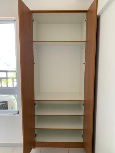 a closet with wooden shelves and a window at Apartamento Estúdio in Teresina