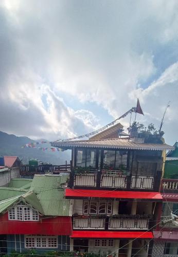 a building with a balcony on top of it at Subba Homestay Sukhia Pokhari Ramjee Road in Sukhia Pokhari