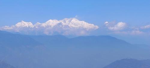 a mountain range with snow capped mountains in the distance at Subba Homestay Sukhia Pokhari Ramjee Road in Sukhia Pokhari