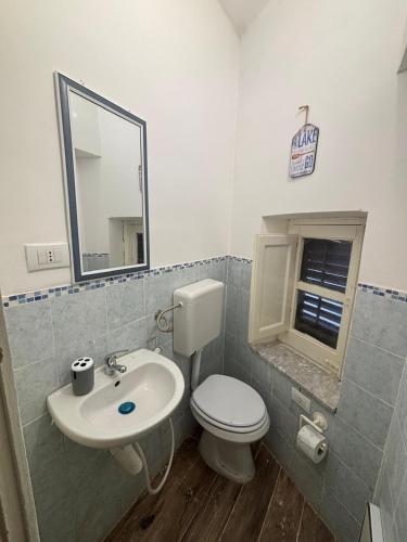 a bathroom with a toilet and a sink and a mirror at Sonalerba Ammare Trabia H H in Trabia