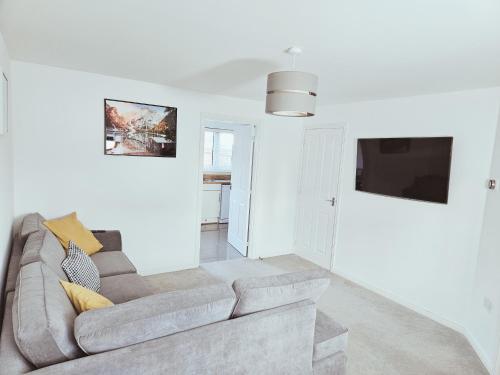 ein Wohnzimmer mit Couch und Flachbildfernseher in der Unterkunft Spacious 3 Bedroom HOUSE in Dartford,London Zone 8 in Dartford