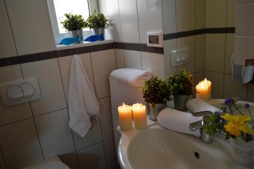 łazienka z 2 świecami i umywalką z ręcznikami w obiekcie Hotel Delfin w mieście Zadar