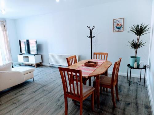 a living room with a wooden table and chairs at Cosy and warm Belfast Central 2 Beds Apartment in Belfast