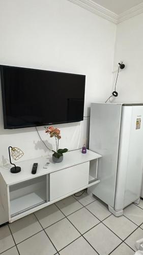 a living room with a tv on a white wall at Pousada Iracema Centro in Fortaleza