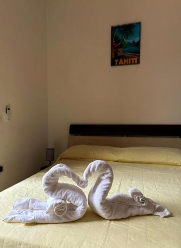 2 cigni fatti di asciugamani su un letto di Station Comfort House a Pagani