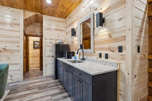 ガトリンバーグにあるWoodys Mountain Lodgeのシンクと電子レンジ付きのキッチン