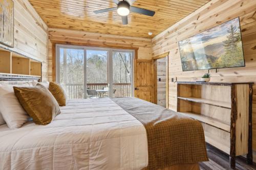 ガトリンバーグにあるWoodys Mountain Lodgeの丸太小屋にある大きなベッドのある寝室