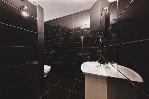 a black bathroom with a sink and a toilet at Midnight Old Town in Bydgoszcz