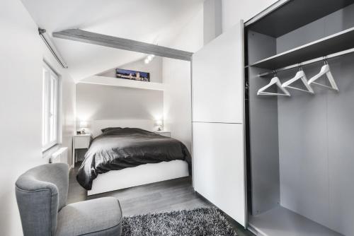 1 dormitorio pequeño con 1 cama y 1 silla en La Maisonnette Alsacienne, en Schiltigheim