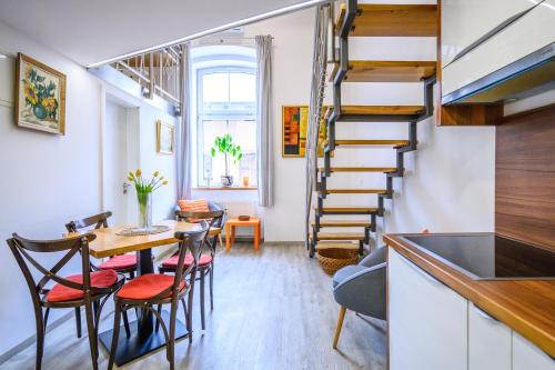 Una sala de estar con una escalera y una mesa y sillas. en The Happy Loft, en Liubliana