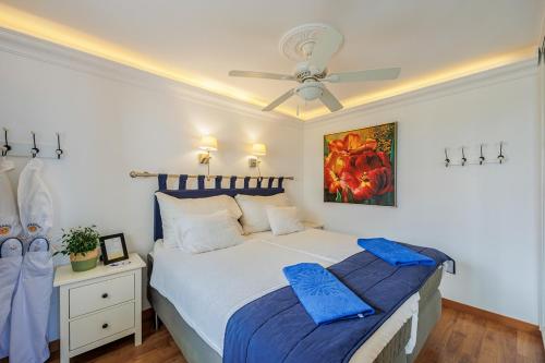 Un dormitorio con una cama y un ventilador de techo. en Sunsuites Collection - Las Flores, en San Bartolomé