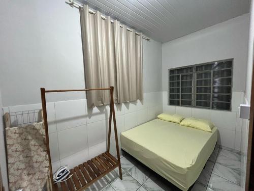 a small bedroom with a bed and a window at Casa da Vila 3 in Cáceres