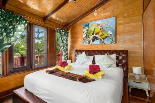 ein Schlafzimmer mit einem Bett mit zwei Hüten darauf in der Unterkunft Beachfront Villa, Private Pool, Stunning Bang Por Beach in Koh Samui 