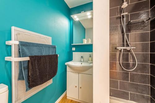 La salle de bains est pourvue de murs bleus et d'une douche. dans l'établissement Villa Léonie Kerlouan, à Kerlouan