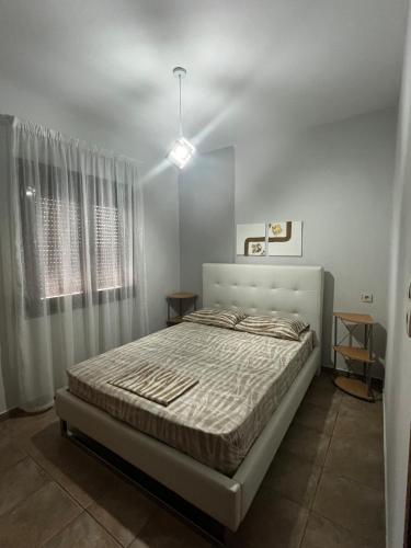 a bedroom with a bed in a white room at Veta's House in Olympiada