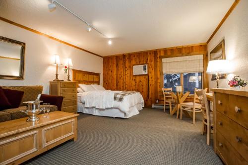 a hotel room with a bed and a table at Kandahar Lodge at Whitefish Mountain Resort in Whitefish