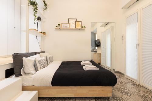 una camera con un letto e una coperta nera di Tiny & Tidy Studio in the key area of Milan a Milano