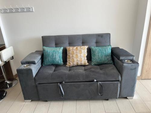 a leather couch with pillows on it in a living room at Lovely View Studio Building Heated Pool Gym Turco WIFI in Quito